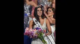Miss Universe 2013, Gabriel Isrel saat menyematkan mahkota ke kepala Paulina Vega yang terpilih sebagai Miss Universe 2014 di FIU Arena, Doral, Miami, Minggu (25/1/2015). (AFP PHOTO/Timothy A. CLARY)