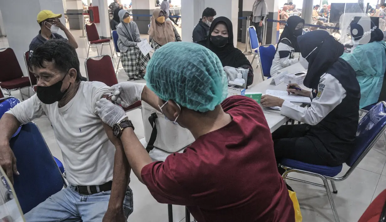 Calon penumpang saat melakukan vaksinasi booster sebelum keberangkatan di Stasiun Pasar Senen, Jakarta Pusat, Minggu (17/7/2022). PT KAI mulai hari ini kembali memberlakukan syarat wajib bagi penumpang kereta jarak jauh, antara lain tes PCR bagi yang baru vaksin pertama dan tes antigen untuk vaksin kedua sebagai langkah mencegah penyebaran Covid-19. (merdeka.com/Iqbal S Nugroho)