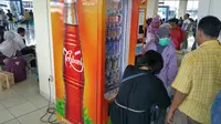 Pemudik di Termina Pulogebang menggunaan mesin penjual minuman.