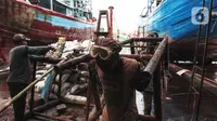Buruh melakukan perbaikan kapal nelayan di Galangan kapal, Muara Angke, Jakarta, Minggu (23/12/2020). Bengkel kapal tersebut menjadi tumpuan pendapatan para pengusaha kapal barang dan ikan. (Liputan6.com/Angga Yuniar)