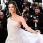 Model Alessandra Ambrosio berpose saat tiba menghadiri pemutaran film "The Dead Don't Die" selama Festival Film Cannes ke-72 di Prancis (14/5/2019). Model cantik asal Brasil ini tampil memesona dengan gaun putih sutra transparan Ralph & Russo. (AFP Photo/Christophe Simon)