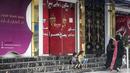 Perempuan berjalan melewati salon kecantikan di daerah Shahr-e Naw di Kabul, Afghanistan pada Selasa (4/7/2023). (Photo by Wakil KOHSAR / AFP)