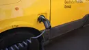 Van listrik Streetscooter mengisi daya di stasiun pengisian di kantor pos Jerman, Deutsche Post di Frankfurt am Main, 21 Juli 2018. Kantor pos Jerman mengganti armada mobil untuk mengirimkan surat dan paket dengan mobil van listrik. (Yann Schreiber/AFP)