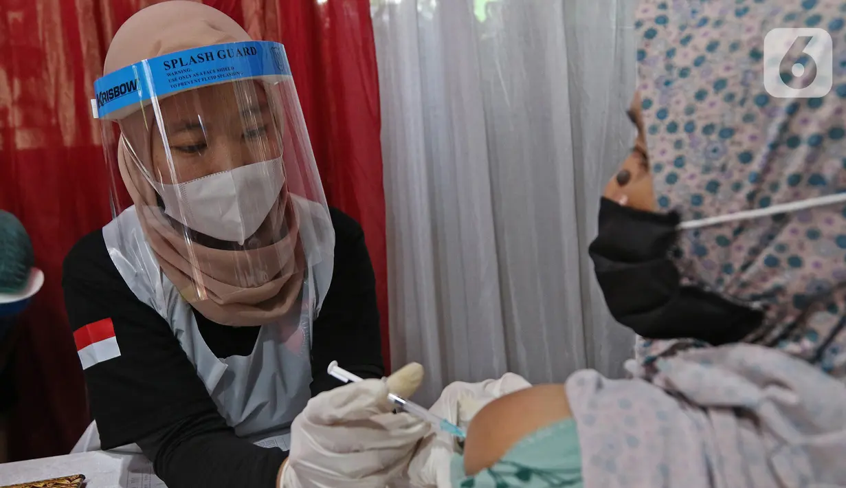 Vaksinator menyuntikkan vaksin COVID-19 kepada warga di Kampung Tangguh Jaya Cideng, Jakarta, Sabtu (10/4/2021). Adapun sasaran program vaksinasi massal ini kaum lanjut usia (lansia) dan pelayan publik yang sering berinteraksi dengan masyarakat. (Liputan6.com/Herman Zakharia)