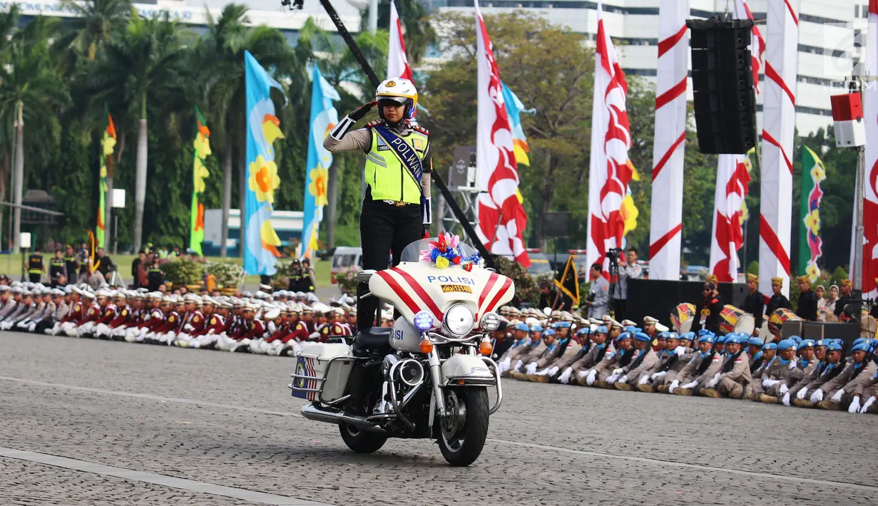 Polisi Wanita (Polwan) unjuk kebolehan dengan berdiri di atas moge pada peringatan HUT Bhayangkara ke-71 di Silang Monas, Jakarta, Senin (10/7). Acara ini menampilkan berbagai atraksi dari masing-masing kesatuan Polri. (Liputan6.com/Angga Yuniar)