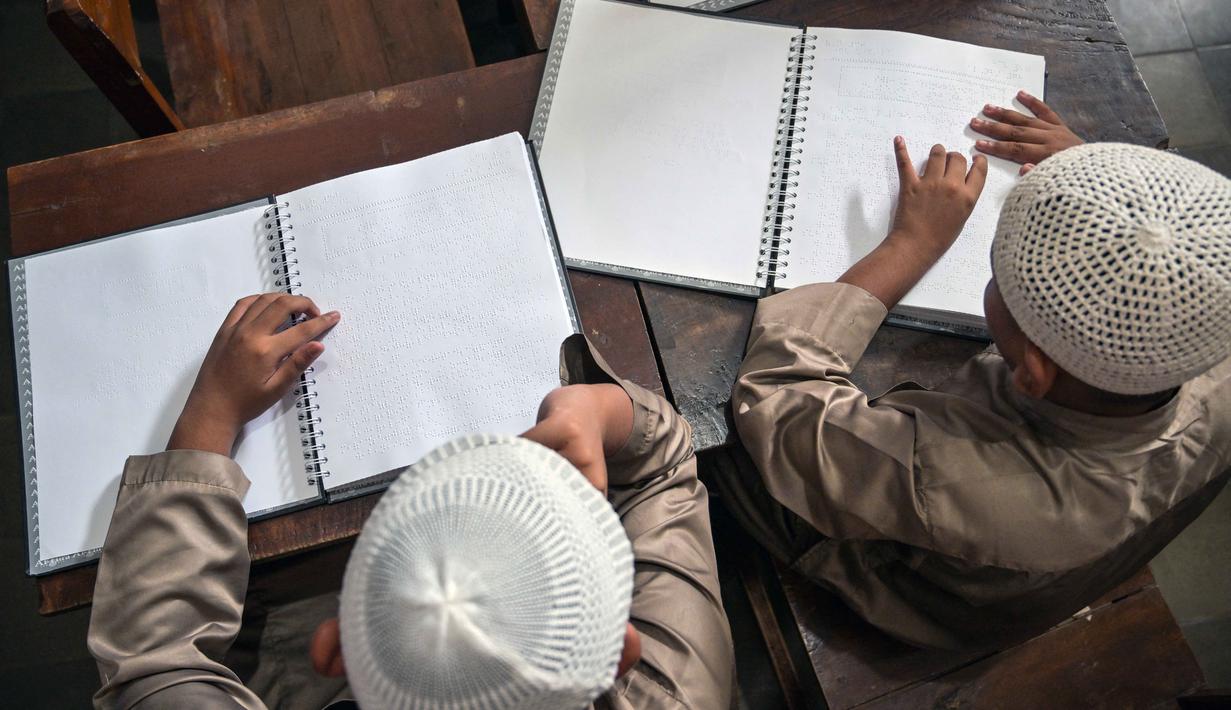 Kegiatan tersebut menjadi agenda rutin selama bulan suci Ramadhan sebagai bagian dari pembinaan keagamaan di lingkungan sekolah. Tampak dalam foto, para siswa tunanetra membaca Al-Quran dalam huruf Braille selama bulan suci Ramadan 1447 Hijriah di sebuah sekolah di Surabaya, Jawa Timur, pada 27 Februari 2026. (JUNI KRISWANTO/AFP)