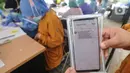 Paramedis menunjukkan SMS undangan vaksin Covid-19 di Puskesmas  Ciganjur, Jakarta Selatan, Kamis (7/1/2021). Pemerintah mulai menjalankan persiapan vaksinasi Covid-19 dengan mendata penerima tahap pertama setelah jutaan vaksin Covid-19 dari Sinovac tiba di Indonesia. (merdeka.com/Arie Basuki)