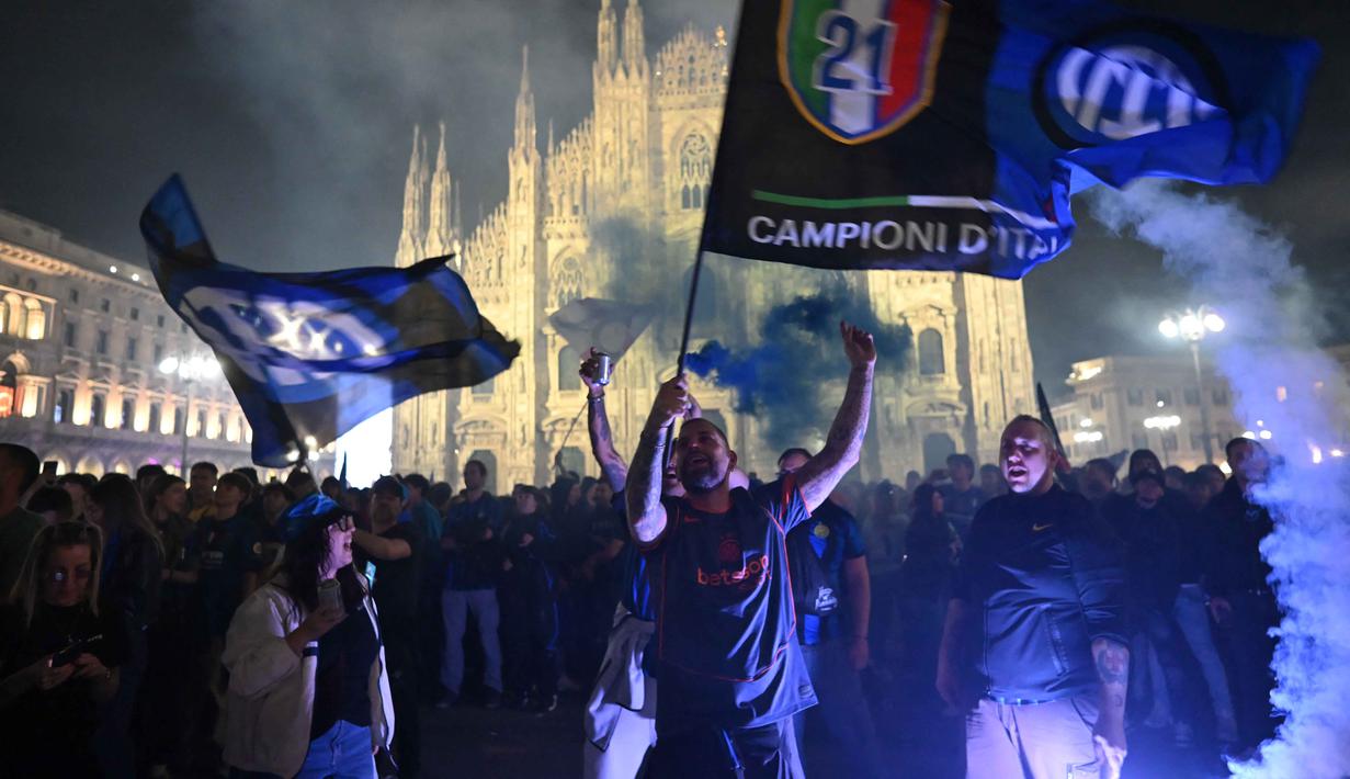 Kemenangan atas Parma pada laga pekan ke-35 ini memastikan perolehan poin Nerazzurri tidak lagi terkejar oleh pesaing terdekatnya, Napoli. Tampak dalam foto, para pendukung Inter Milan merayakan gelar juara Serie A musim 2025/2026 atau scudetto ke-21 di Piazza Duomo, Milan, Italia, Minggu (3/4/2026) malam waktu setempat atau Senin (4/5/2026) dini hari WIB. (PIERO CRUCIATTI/AFP)