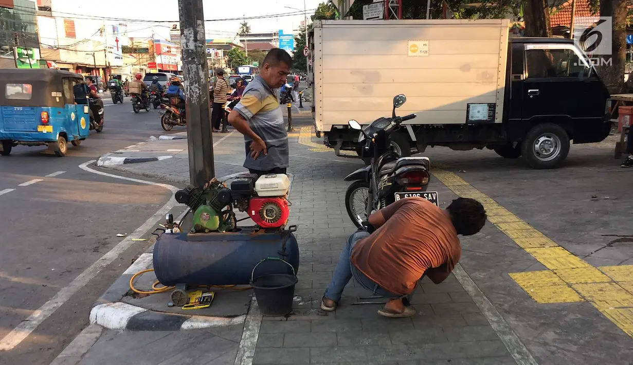 Mobil menutup sebagian badan trotoar di kawasan Jatinegara, Jakarta, Senin (24/9). Kondisi trotoar yang telah diperlebar Pemprov DKI Jakarta kini dipenuhi PKL dan parkir liar sehingga mengganggu kenyamanan pejalan kaki. (Liputan6.com/Immanuel Antonius)