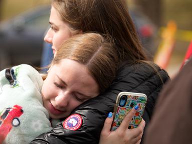 Dua wanita berpelukan setelah penembakan sekolah di East High School, Denver, Colorado, Amerika Serikat, Rabu (22/3/2023). Dua administrator sekolah ditembak di SMA tersebut setelah pistol ditemukan pada seorang siswa yang diperiksa. (AP Photo/David Zalubowski)