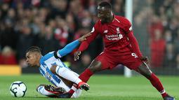 Gelandang Liverpool, Naby Keita berebut bola dengan pemain Huddersfield Town, Juniunho Bacuna dalam laga lanjutan Premier League 2018-19 pekan ke-36 di Anfield, Jumat (26/4). Bermain di kandang sendiri, Liverpool menang dengan skor telak 5-0.  (AP Photo/Jon Super)