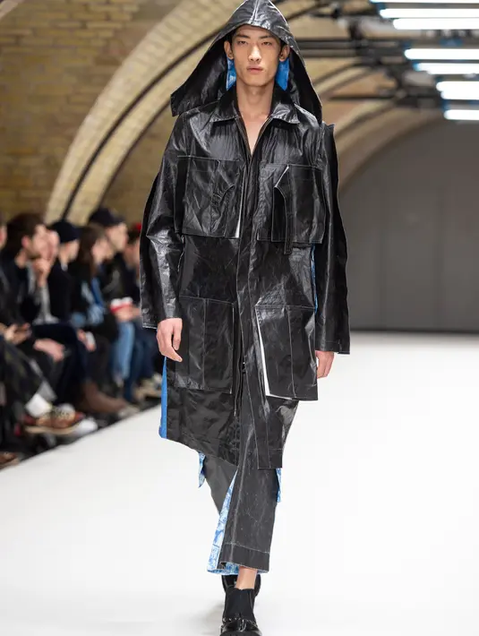 Model membawakan busana kreasi dari perancang Inggris, Craig Green selama gelaran London Fashion Week Men's di London pada 7 Januari 2019. Craig Green menampilkan busana warna-warni berbahan plastik minyak dengan pola yang rumit. (NIKLAS HALLE'N/AFP)