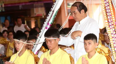 Pelatih tim sepak bola remaja Thailand, Ekkapol Janthawong (tengah) bersama anak asuhnya mengikuti ritual di Distrik Mae Sai, Chiang Rai, Kamis (19/7). Ritual ini diyakini memperpanjang hidup serta membersihkan mereka dari bahaya. (AP Photo/Sakchai Lalit)