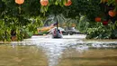 Orang-orang menyusuri jalan yang terendam banjir dengan perahu setelah hujan deras di Hoi An pada Kamis 30 Oktober 2025. Provinsi-provinsi pesisir Vietnam telah dilanda hujan deras sejak 26 Oktober 2025, dengan rekor curah hujan hingga 1,7 meter (lima kaki tujuh inci) dalam 24 jam terakhir. (NHAC NGUYEN/AFP)