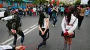 Para wanita berjalan dengan tangan terikat saat memperingati Hari Anti Kekerasan Perempuan di Santiago, Chile (25/11). (REUTERS/Rodrigo Garrido)