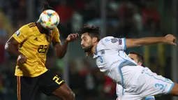 Striker Belgia, Michy Batshuayi, duel udara dengan bek San Marino, Mirko Palazzi, pada laga Kualifikasi Piala Dunia 2022 di Olympic Stadium, Serravalle, Jumat (6/9). San Marino kalah 0-4 dari Belgia. (AFP/Isabella Bonotto)