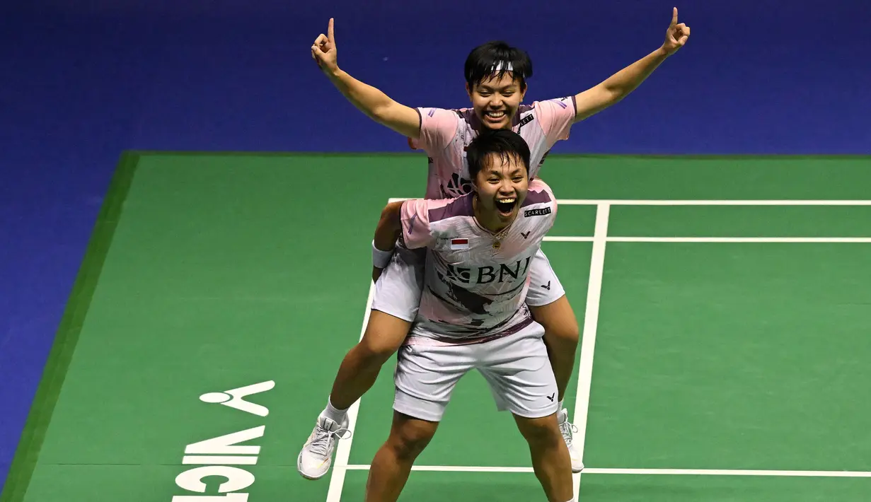 Selebrasi ganda putri Indonesia, Apriyani Rahayu (bawah) dengan menggendong rekannya, Siti Fadia Silva Ramadhanti setelah menyudahi perlawanan wakil Malaysia, Pearly Tan/Thinaah Muralitharan pada laga final ganda putri Hong Kong Open 2023 di Hong Kong Coliseum, Minggu (17/9/2023) siang WIB. Apriyani/Siti Fadia menang rubber game 14-21, 24-22 dan 21-9. (AFP/Peter Parks)