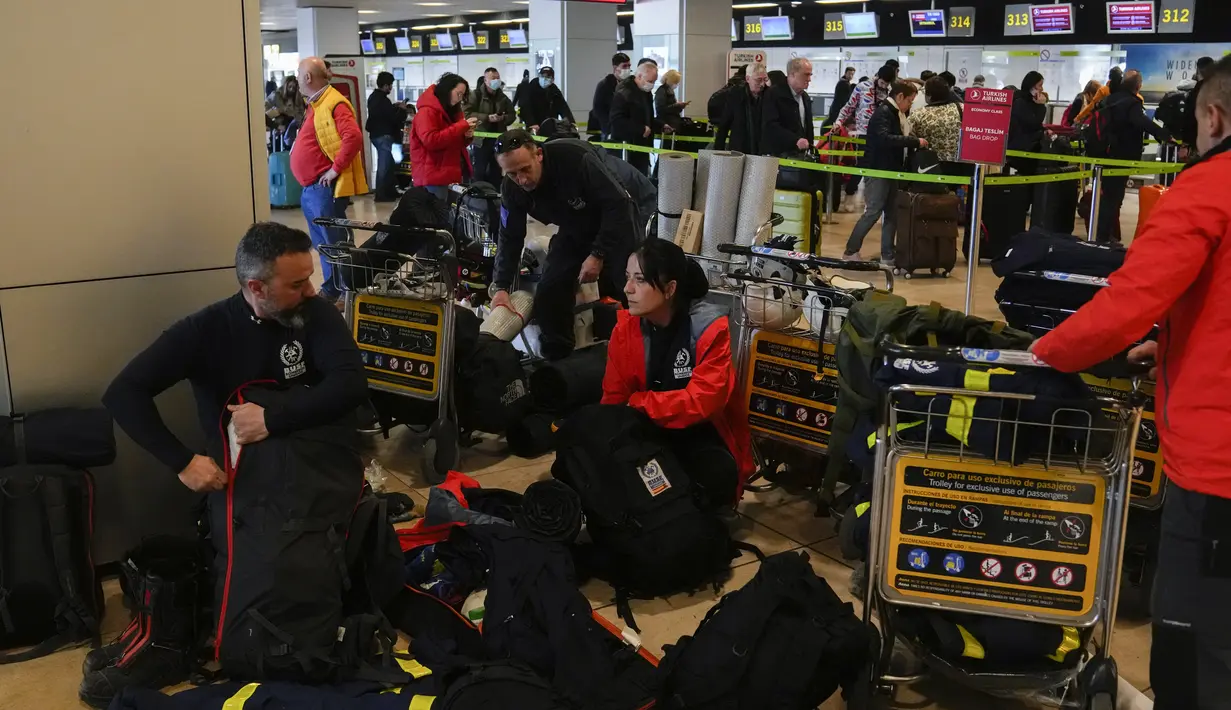 Petugas pemadam kebakaran Spanyol dengan peralatan mereka sebelum naik pesawat untuk membantu misi penyelamatan gempa Turki, di bandara internasional Barajas, di Madrid, Spanyol, Senin (6/2/2023). Gempa kuat telah merobohkan beberapa bangunan di Turki tenggara dan Suriah dan banyak korban dikhawatirkan. (AP Photo/Paul White)