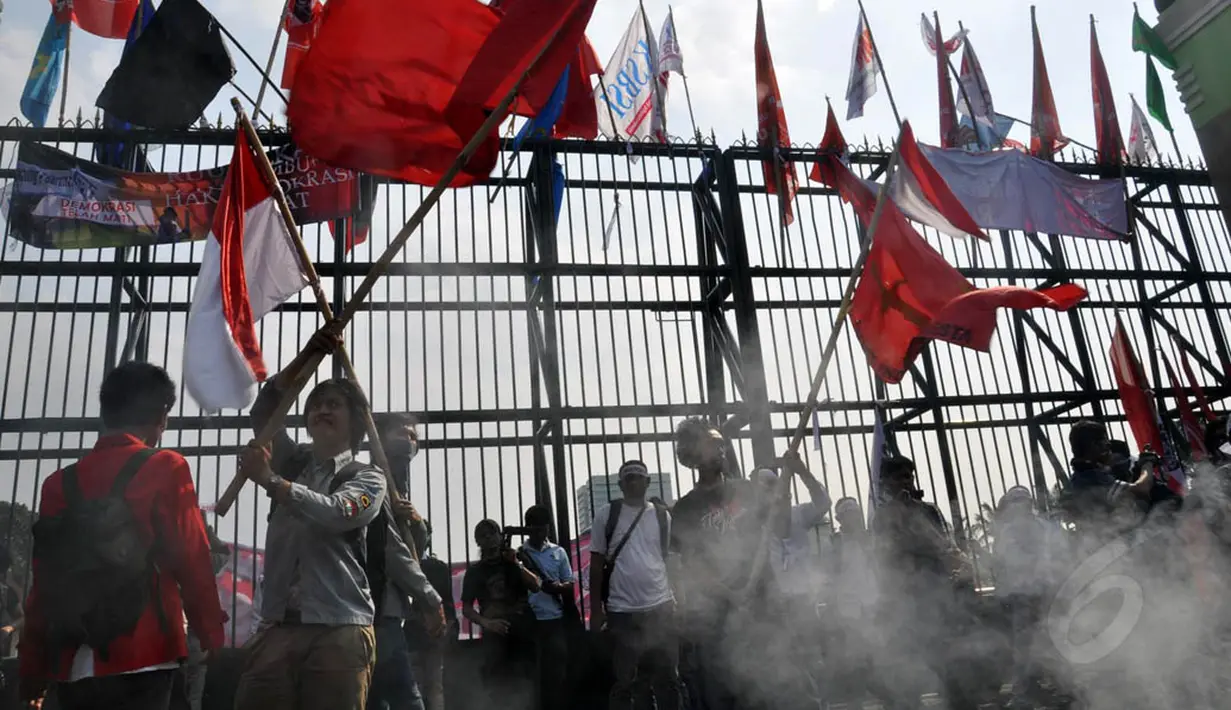 Dengan membawa bendera dan spanduk, massa terus menerus meneriakkan aspirasinya di depan pagar Gedung DPR RI, Jakarta, (11/9/14). (Liputan6.com/Miftahul Hayat)