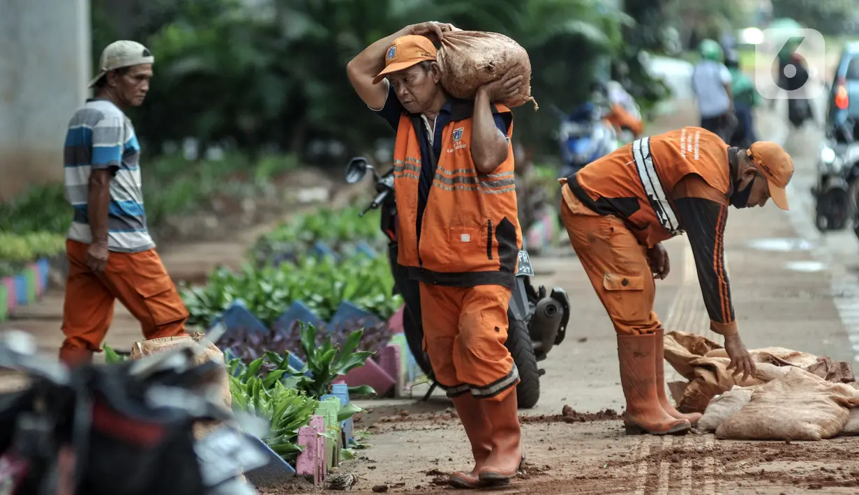 Petugas penanganan prasarana dan sarana umum (PPSU) Kelurahan Cipinang Besar Selatan saat menyelesaikan pembuatan taman di Jalan DI Panjaitan, Jakarta Timur, Rabu (14/12/2022). Berdasarkan data Badan Kepegawaian Daerah (BKD) DKI melalui e-PJLP, jumlah petugas di DKI Jakarta hingga saat ini mencapai 85.310 orang. (merdeka.com/Iqbal S. Nugroho)