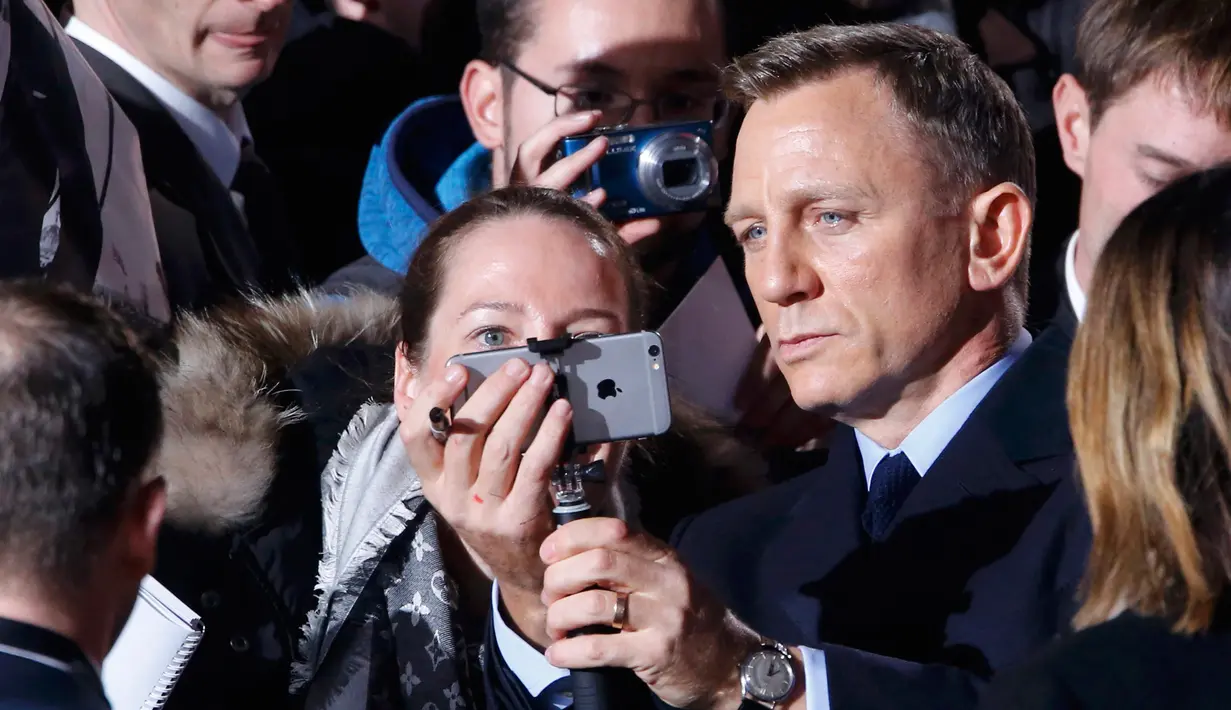 Aktor Daniel Craig berselfie dengan penggemarnya saat menghadiri premiere film terbarunya James Bond 007 "Spectre" di Berlin, Jerman, (28/10/2015). Film tersebut dirilis pada tanggal 6 November 2015. seri film James Bond. (REUTERS/Fabrizio Bensch)
