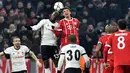 Gelandang Besiktas, Atiba Hutchinson berebut bola dengan pemain Bayern Munchen, Thomas Mueller pada pertandingan pertama babak 16 besar Liga Champions di Allianz Arena, Selasa (20/2).  Bayern melumat Besiktas lima gol tanpa balas. (Thomas KIENZLE/AFP)