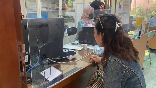 Seorang pasien mendaftar di loket Puskesmas Dinoyo Malang