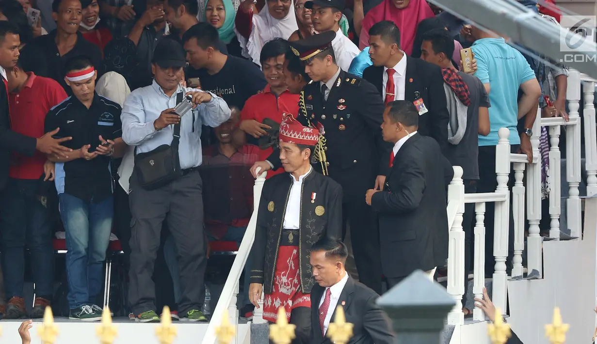 Presiden Joko Widodo atau Jokowi menyempatkan diri menyalami tamu undangan di halaman Istana Merdeka, Jakarta, Kamis (17/8). Hal ini disambut meriah para tamu yang kemudian bangkit berebut untuk berfoto bersama Jokowi. (Liputan6.com/Angga Yuniar)