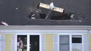 Pesawat ringan bermesin satu yang menabrak atap kondominium di Methuen, Massachusetts, (1/3). Dalam kejadian ini pilot pesawat tewas. (AP/Elise Amendola)