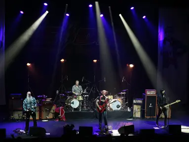 Grup rock Eagles of Death Metal tampil di atas panggung gedung teater Olympia, Paris, Selasa (16/2). Grup rock asal California itu menggelar konser di hadapan ratusan penggemar yang selamat dari serangan teror pada November lalu. (AFP PHOTO/Joel SAGET)