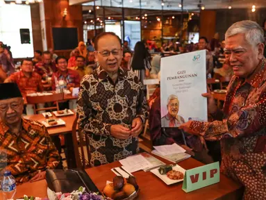 Prof Soekirman secara simbolis memberikan buku kepada Gus Solahudin Wahid pada peluncuran buku Gizi Pembangunan di Jakarta, Sabtu (01/10). Buku tersebut berisi kumpulan tuisan Soekirman dari IPB selama tahun 1962-2015. (Liputan6.com/Fery Pradolo)
