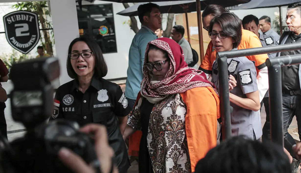 Petugas menggiring komedian Tri Retno Prayudati alias Nunung sebelum rilis kasus narkoba di Ditnarkoba Polda Metro Jaya, Jakarta, Senin (22/7/2019). Nunung ditangkap bersama suaminya, July Jan Sambiran, usai bertransaksi narkoba dengan tersangka TB di kediaman mereka. (Liputan6.com/Faizal Fanani)
