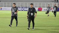 Pelatih Timnas Indonesia U-20, Indra Sjafri (kanan) didampingi asisten pelatih, Bima Sakti berjalan memasuki lapangan jelang dimulainya laga uji coba internasional menghadapi Timnas China U-20 di Stadion Madya Gelora Bung Karno, Senayan, Jakarta, Jumat (22/3/2024). (Bola.com/Abdul Aziz)