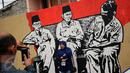 Warga berfoto di depan gambar Tiga Bapak Bangsa di Lapangan Kebagusan, Jakarta, Rabu (15/2). Jelang menggunakan hak pilihnya pada Pilkada, Ketua Umum PDI-P Megawati Soekarnoputri menggoreskan tinta pada salah satu gambar. (Liputan6.com/Helmi Fithriansyah)