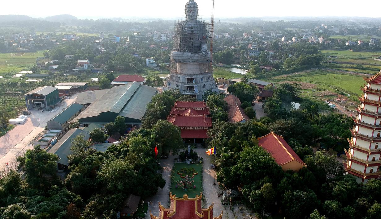 Foto udara pada 18 Mei 2019 memperlihatkan patung Buddha raksasa yang sedang dibangun di pagoda Khai Nguyen di distrik Son Tay, pinggiran Hanoi. Pengerjaan patung Buddha setinggi 72 meter ini dimulai pada 2015 dan diperkirakan selesai dalam lima tahun mendatang. (Photo by Manan VATSYAYANA/AFP)