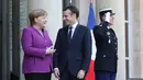 Kanselir Jerman Angela Merkel berbincang dengan Presiden Emmanuel Macron saat kedatangannya di Paris (16/3). Sementara Jerman hingga saat ini bersikap lebih hati-hati, karena Jerman adalah salah satu penyandang dana Uni Eropa. (AFP Photo/Ludovic Marin)