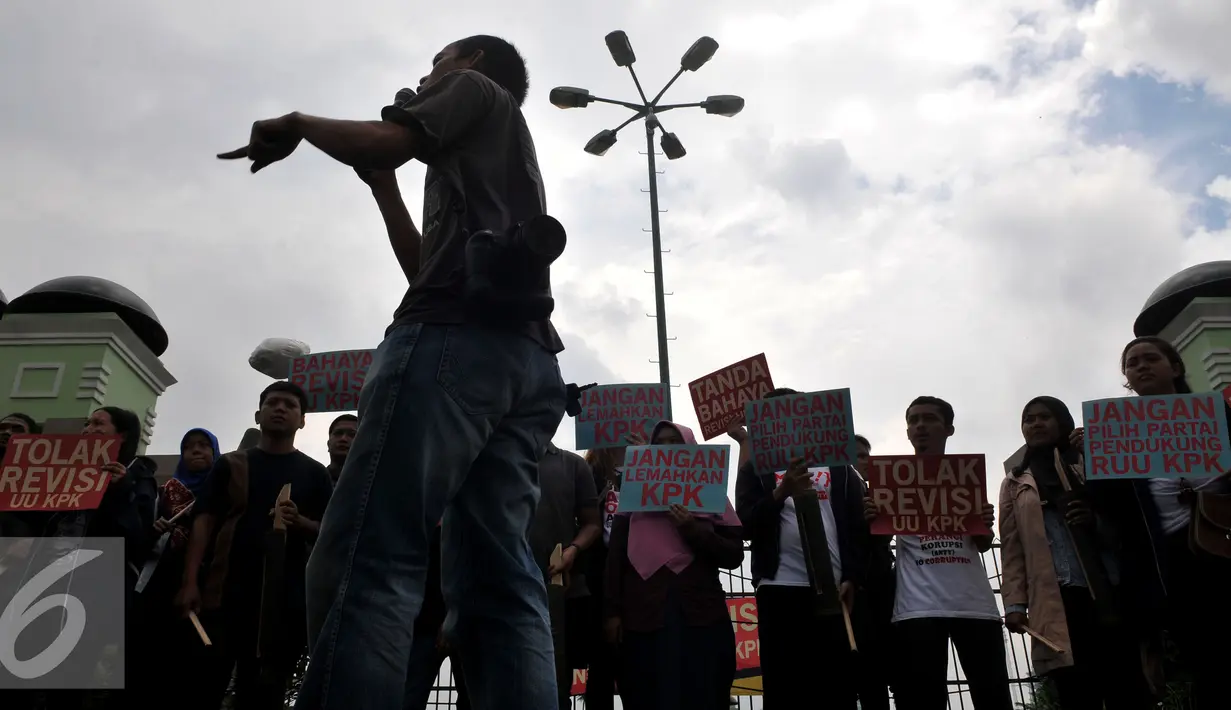 Demonstran dari Koalisi Masyarakat Sipil Antikorupsi dan Musisi berteriak saat menggelar Aksi memasang spanduk di Depan gedung DPR, Jakarta, Rabu (17/2/2016). Dalam aksinya mereka menuntut  "Tolak Revisi UU KPK".(Liputan6.com/Johan Tallo)