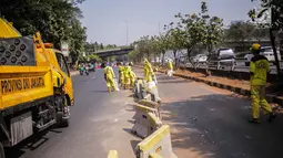 Petugas Dinas Bina Marga DKI Jakarta memperbaiki separator busway di kawasan Jalan Gatot Subroto, Jakarta, Selasa (1/10/2019). Separator busway dirusak massa saat terjadi bentrok antara polisi dengan demonstran di kawasan tersebut. (Liputan6.com/Faizal Fanani)