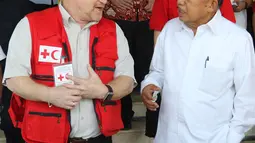 Ketua Umum Palang Merah Indonesia, Jusuf Kalla berbincang dengan Kepala IFRC Perwakilan Indonesia-Timor Leste dan ASEAN, Jan Gelfand, saat penyerahan secara simbolis bantuan 10 unit truk tangki air dan satu truk barang di Markas PMI Pusat, Jakarta, Jumat (17/1/2020). (Liputan6.com/Herman Zakharia)