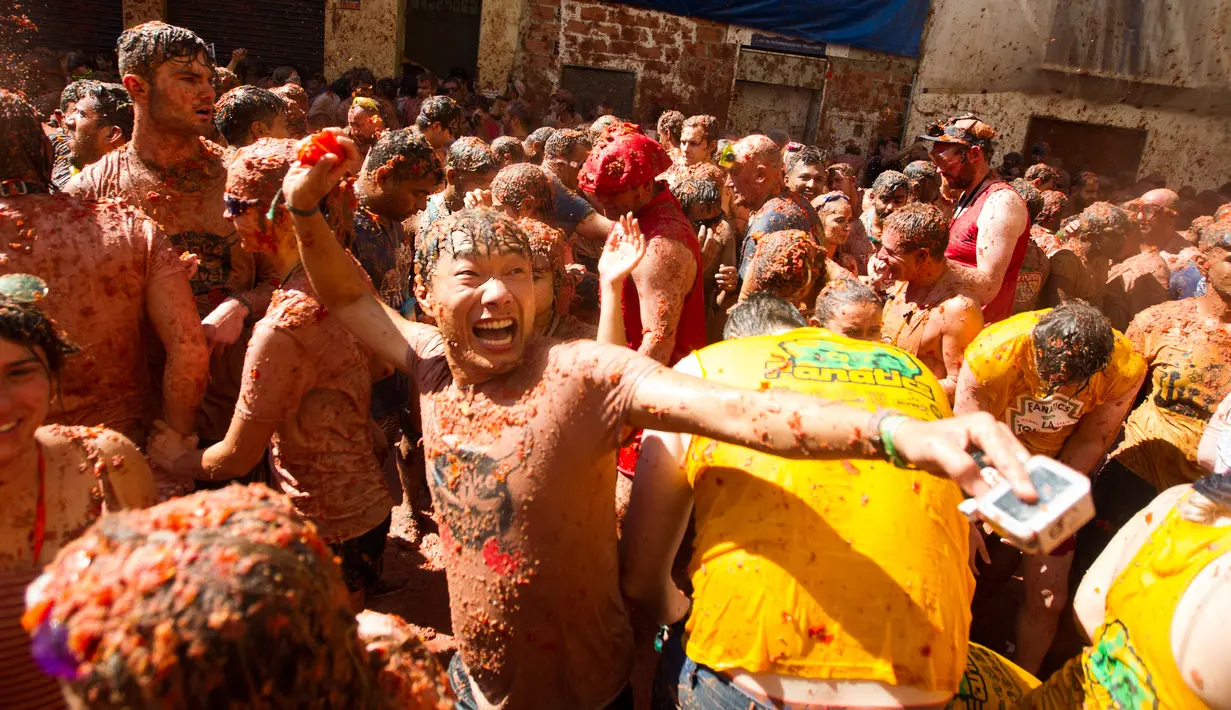 Peserta saling melemparkan tomat saat festival tahunan "Tomatina" di Bunol, salah satu kota di timur Spanyol, Rabu (29/8/2019). Digelar sejak 1945, perang tomat ini menjadi daya tarik utama bagi wisatawan mancanegara seperti dari Inggris, Jepang, dan Amerika Serikat. (JAIME REINA / AFP)