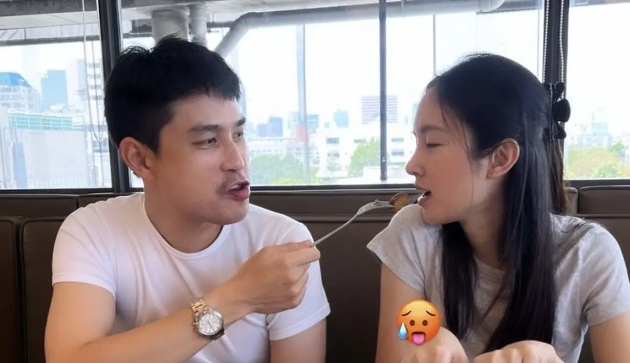 Seperti pengantin baru pada umumnya, Nong Poy dan suami nampak begitu romantis. Bahkan keduanya tampil kompak mengenakan tshirt putih saat makan bersama. Credit: @poydtreechada
