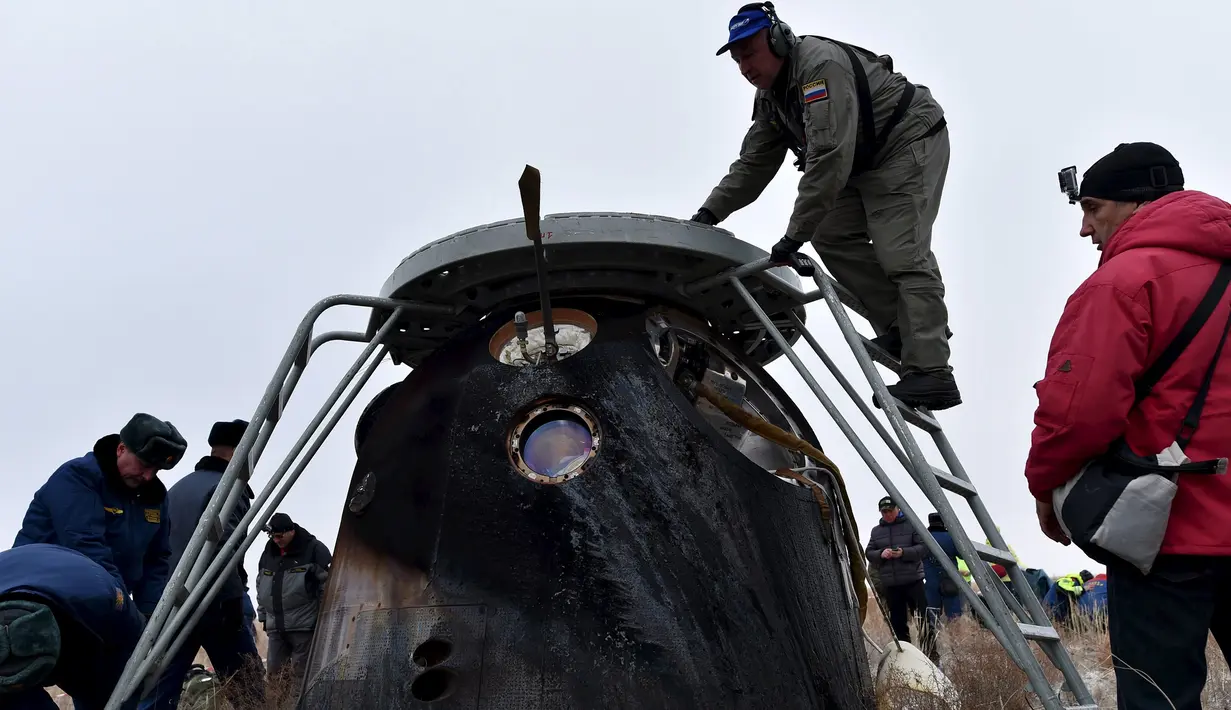 Petugas penyelamat saat memeriksa kondisi pesawat kapsul yang mendarat di kota Dzhezkazgan, Kazakhstan , (2/3). Pesawat kapsul Soyuz tersebut membawa yang membawa tiga penumpang yaitu Kelly, Kornienko dan Sergey Volkov.  (REUTERS / Kirill Kudryavtsev)