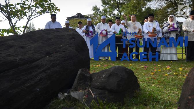 Walikota Higashi Matsusima, Jepang, Iwao Atsumi (tengah) bersama ulama dan tokoh masyarakat menabur bunga saat peringatan 14 tahun tsunami di Kuburan Massal Ulee Lheue, Banda Aceh, Rabu (26/12). (Chaideer MAHYUDDIN / AFP)