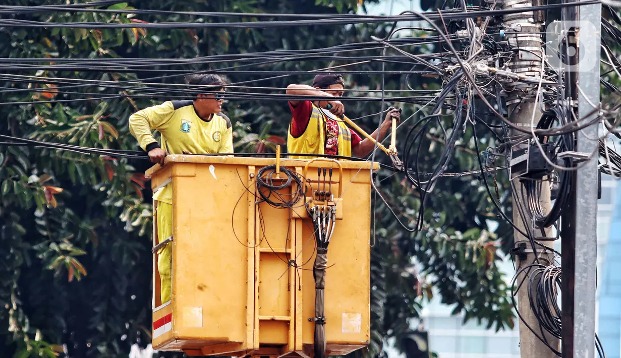 Petugas Dinas Bina Marga melakukan penertiban kabel yang menjuntai di kawasan Jakarta Barat, Rabu (2/8/2023). Imbas kecelakaan mahasiswa akibat kabel yang menjuntai, petugas melakukan penertiban kabel yang semrawut agar tidak membahayakan masyarakat. (Liputan6.com/Angga Yuniar)
