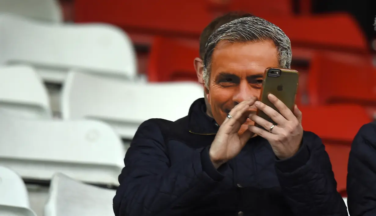 Seorang Suporter santai menggunakan topeng pelatih Chelsea Jose Mourinho pada laga Liga Premier Inggris di Stadion Britania, Minggu (8/11/2015) dini hari WIB. Mourinho dilarang mendampingi timnya oleh Football Association ( FA ). (AFP Photo/Paul Ellis)
