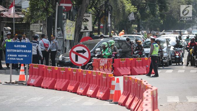 Petugas mengatur lalu lintas saat uji coba sistem satu arah (SSA) di Jalan KH Wahid Hasyim, Jakarta, Selasa (9/10). Sejumlah petugas terlihat berjaga di persimpangan menuju empat ruas jalan tersebut. (Liputan6.com/Faizal Fanani)