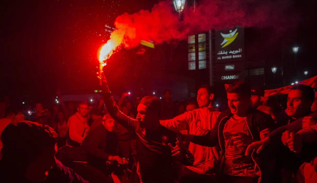 Warga Maroko menyalakan flare merayakan keberhasilan negaranya lolos ke Piala Dunia 2018 di Rabat, Sabtu (11/11/2017). Maroko lolos setelah mengalahkan Pantai Gading 2-0 pada laga penentu. (AFP/Fadel Senna)