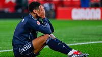 Pemain Real Madrid, Jude Bellingham, menutup wajahnya lantaran kecewa setelah bermain imbang 1-1 ketika menghadapi tuan rumah Girona pada laga lanjutan La Liga 2025/2026 di Montilivi, Senin (1/12/2025) dini hari WIB. (AP Photo/Joan Monfort)