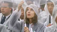 Seorang wanita tampak menggunakan jas hujan dan mpayung saat peringatan 69 tahun tragedi bom Hiroshima di Peace Memorial Park, Rabu (6/8/14). (REUTERS/Kyodo)