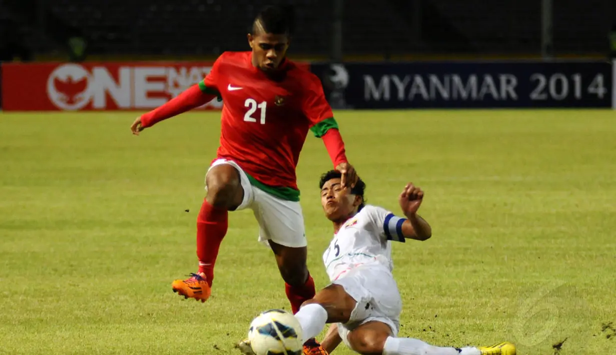 Yabes Roni Malaifani (Indonesia U-19) meloncat menghindari tackling keras pemain Myanmar, Nanda Kyaw saat berlaga di Stadion GBK Jakarta, (5/5/2014). (Liputan6.com/Helmi Fithriansyah)